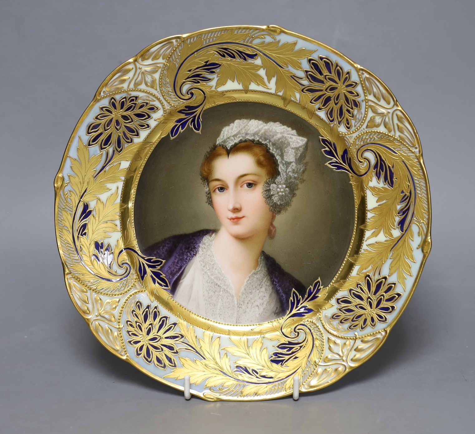 A late 19th century Vienna style painted portrait dish, titled Einer Tiroler Wirtin, 24.5cm